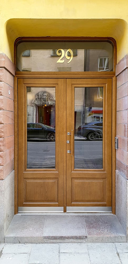 Double entrance door from Ekstrands, the entrance hall's transom has rounded corners and gold text in glass