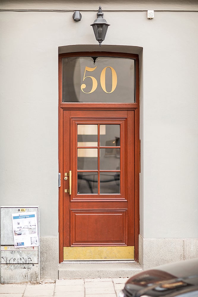 Entrance door in Stockholm with transom light and gold text, solid oak doors from Ekstrands