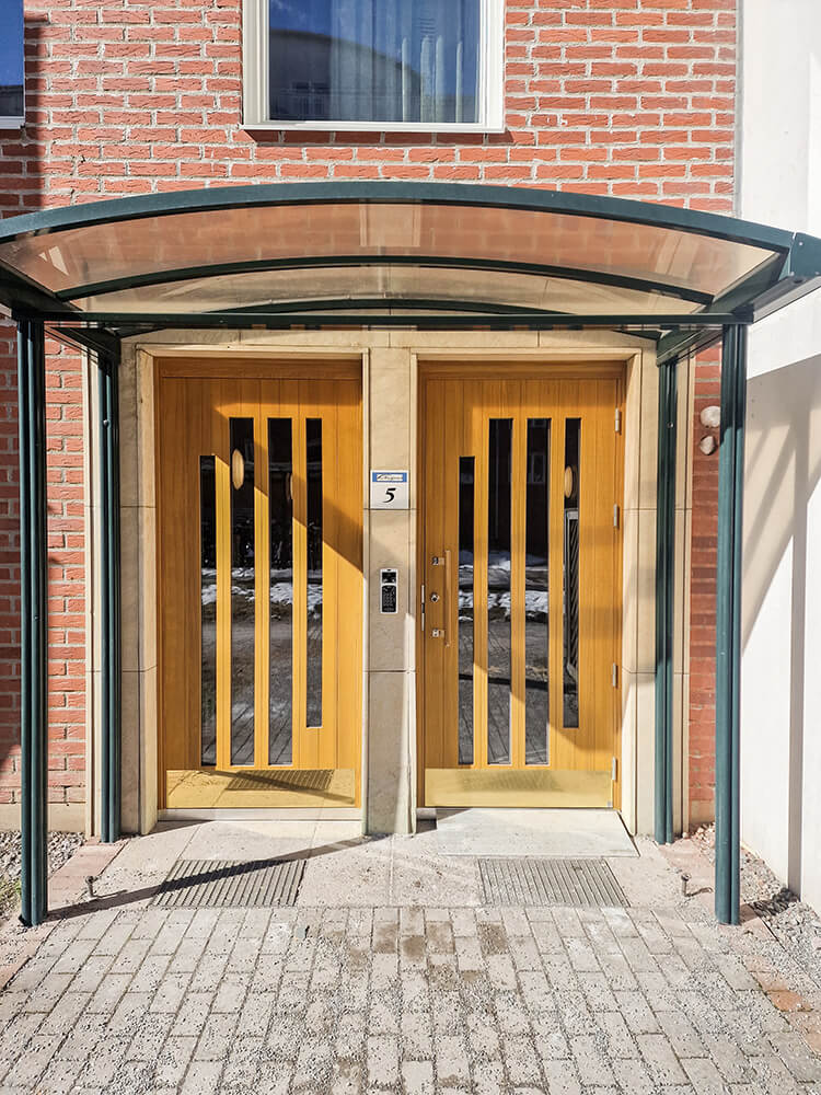 Entrédörrar i specialdesign med mässingsparkplåt och draghandtag i laserad ek