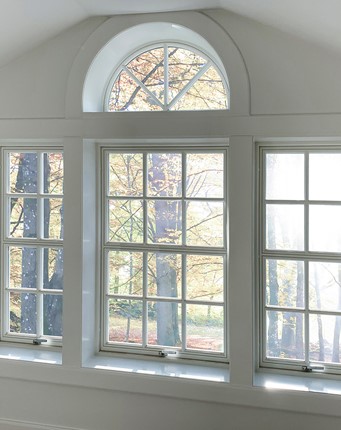 Vridfönster med spröjs och glasdelande poster i klassiskt utseende och halvrunt fönster