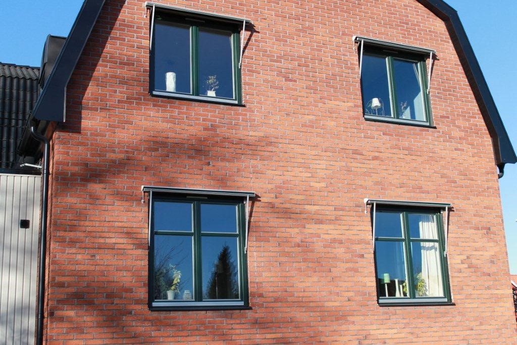 Inåtgående fönster på äldre tegelfasad