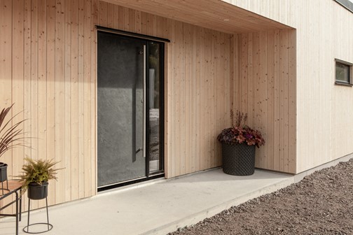 Ytterdörr Berg 160 Noir i miljö med draghandtag D2R rostfritt och sidoljus SL110 i svart