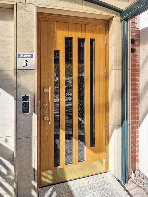 Entrédörr från Ekstrands i specialdesign med mässingsparkplåt och draghandtag i laserad ek